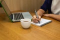 Woman hand with pen writing on notebook at coffee shop Royalty Free Stock Photo