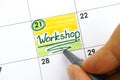 Woman hand with pen writing reminder Workshop in calendar Royalty Free Stock Photo