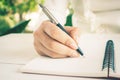 Woman hand with pen writing on white notebook. Royalty Free Stock Photo