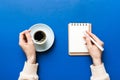 Woman hand with pencil writing on notebook and hold coffee cup. Woman working on office table with coffee Royalty Free Stock Photo