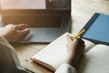 Woman hand with pencil writing on notebook. making notes in notebook with pencil. People writing on notebook and work on wooden Royalty Free Stock Photo