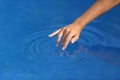 Woman hand with perfect manicure playing with water in a pool