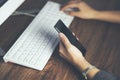 Woman hand phone with working keyboard on table Royalty Free Stock Photo