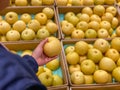 Woman hand picking fresh yellowish pear at grocery store Royalty Free Stock Photo