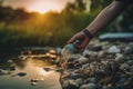 woman hand picking up garbage plastic for cleaning at river with sunset. AI Generative Royalty Free Stock Photo