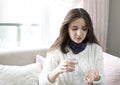 Woman hand with pills medicine tablets and glass of water in her hands. Royalty Free Stock Photo