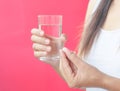 Woman hand with pills medicine tablets and glass of water Royalty Free Stock Photo