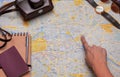 Woman hand pointing to a vintage Berlin map with her travel kit