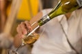 Woman hand pouring white wine from bottle into glass on white Royalty Free Stock Photo