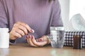 Woman hand preparing to take medicine with glass of water and bottle of pill on desk Royalty Free Stock Photo