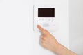 Woman hand presses on button of modern intercom