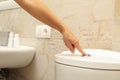 Woman hand presses the toilet flush button Royalty Free Stock Photo