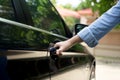 Woman hand pulling car door handle to open the a car Royalty Free Stock Photo