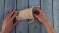 woman hand pulls reusable organic cotton pad out of knitted eco bag.