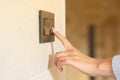 Woman hand pushing light switch at home Royalty Free Stock Photo