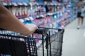 woman hand pushing a shopping cart in a supermarket store Royalty Free Stock Photo