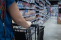 Woman hand pushing a shopping cart in a supermarket store Royalty Free Stock Photo