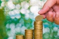 Woman hand put coin on step of coins stacks and gold coin money Royalty Free Stock Photo