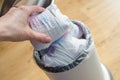 Woman hand put used diaper to the Trash bin full of used diapers. Close up Royalty Free Stock Photo