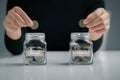 Woman hand putting coin in the glass jar for saving and emergency, Saving for Emergency concept Royalty Free Stock Photo