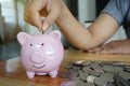 Woman hand putting coin on piggy bank. Saving maney concept. Royalty Free Stock Photo
