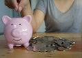 Woman hand putting coin on piggy bank. Saving maney concept. Royalty Free Stock Photo