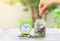 Woman hand putting Coins in glass jar for money saving for retirement concept Royalty Free Stock Photo