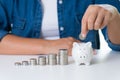 Woman hand putting money coin into piggy bank with stack of coin Royalty Free Stock Photo