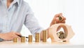 Woman hand putting money coin into piggy bank with step of growing stack coins for saving money for future investment concept Royalty Free Stock Photo