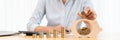 Woman hand putting money coin into piggy bank with step of growing stack coins for saving money for future investment concept Royalty Free Stock Photo