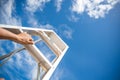 Woman Hand Reaching For Red Ladder Leading To A Blue Sky Royalty Free Stock Photo