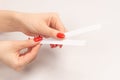 Woman hand with red nails with test strips for the perfume, isolated on a white background Royalty Free Stock Photo