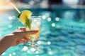 Woman hand with refreshing lemon cocktail, in swimming pool