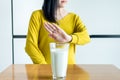 Woman hand refusing a glass of milk,Female having allergy milk,Lactose intolerance concept