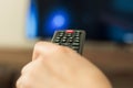 Remote control woman hand. Background blur tv Royalty Free Stock Photo