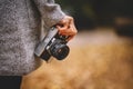 Woman hand with retro analog film camera. Concept for travel, wanderlust, outdoor adventure. Natural fall, defocused