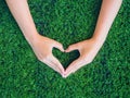 Woman hand in shape of heart on green grass background Royalty Free Stock Photo