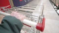 Woman hand with shopping cart in supermarket