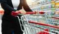 Woman hand with shopping cart in a supermarket Royalty Free Stock Photo