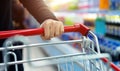 Woman hand with shopping cart in a supermarket Royalty Free Stock Photo