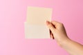 Woman hand showing blank business card on pink background. Royalty Free Stock Photo