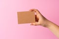 Woman hand showing blank business card on pink background. Royalty Free Stock Photo