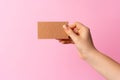 Woman hand showing blank business card on pink background. Royalty Free Stock Photo