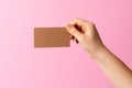 Woman hand showing blank business card on pink background. Royalty Free Stock Photo