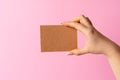 Woman hand showing blank business card on pink background. Royalty Free Stock Photo