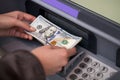 Woman hand showing dollar banknotes in front of the atm Royalty Free Stock Photo