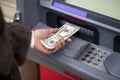 Woman hand showing dollar banknotes in front of the atm Royalty Free Stock Photo