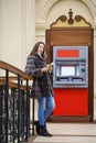 Woman hand showing dollar banknotes in front of the atm Royalty Free Stock Photo