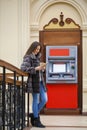 Woman hand showing dollar banknotes in front of the atm Royalty Free Stock Photo