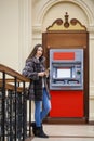 Woman hand showing dollar banknotes in front of the atm Royalty Free Stock Photo